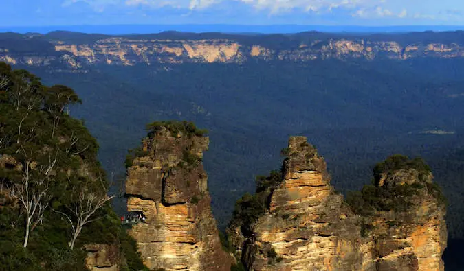 The three sisters in the Blue Mountains of Australia with blue sky and lush background