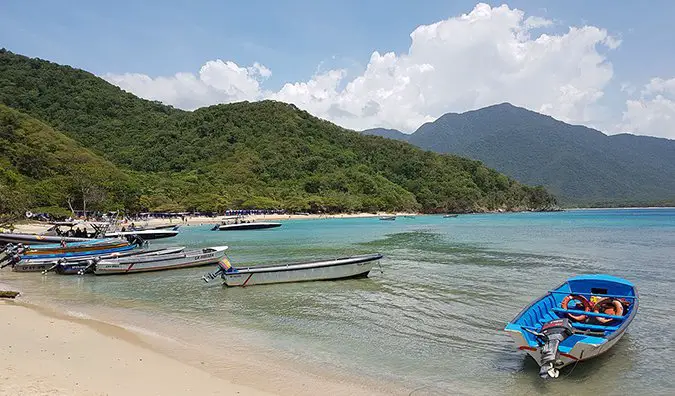 boats pulled up on a sandy beach in Tayrona National Park