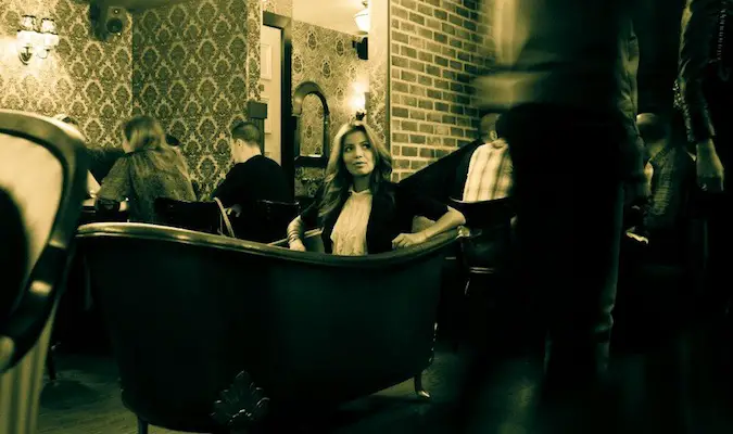 Girl sitting in a bathtub, a highlight of the popular NY speakeasy appropriately named Bathtub Gin